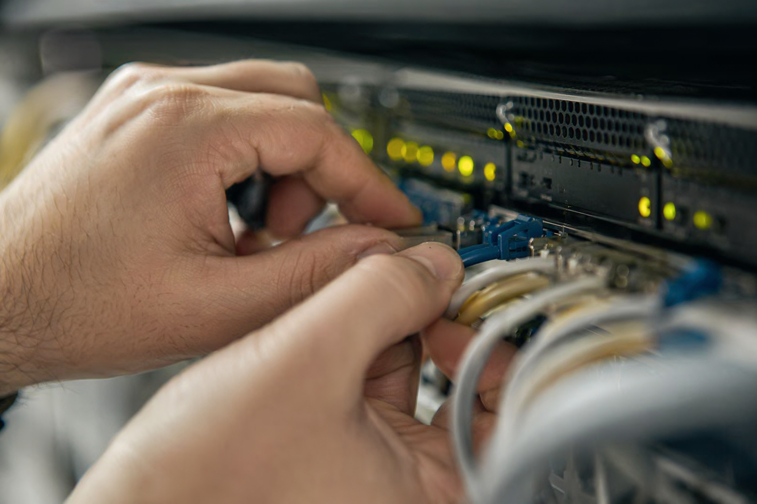 Close-up hands adjusting email security appliance dials and ports